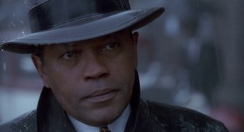 Movie still from “Hoodlum” (1997), directed by Bill Duke – A person wearing a suit and a hat; Close Up shot, Low angle