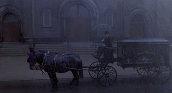 Movie still from “Hoodlum” (1997), directed by Bill Duke – A man riding a horse drawn carriage on a rainy day; Extreme Wide shot, High angle