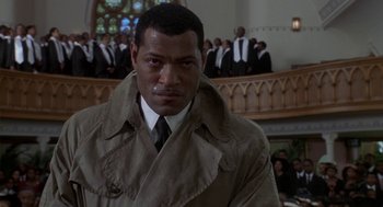 Movie still from “Hoodlum” (1997), directed by Bill Duke – A man wearing a trench coat and tie; Close Up shot, Low angle
