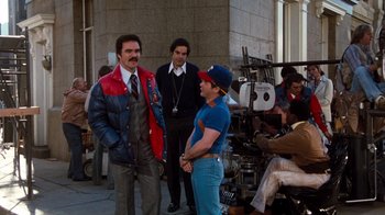 Movie still from “Hooper” (1978), directed by Hal Needham – A group of men standing next to each other on a sidewalk; Wide shot, Over the shoulder angle