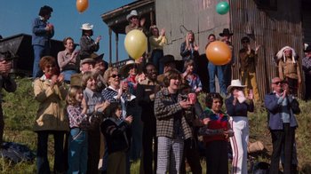 Movie still from “Hooper” (1978), directed by Hal Needham – A group of people standing in front of a building with balloons; Wide shot, High angle
