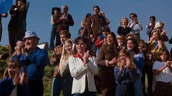 Movie still from “Hooper” (1978), directed by Hal Needham – A group of people standing next to each other clapping; Wide shot, High angle