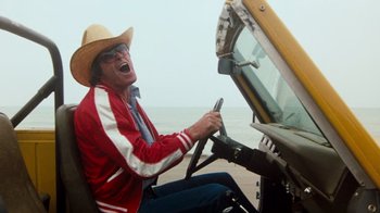 Movie still from “Hooper” (1978), directed by Hal Needham – An older man in a cowboy hat driving a truck; Medium shot, Low angle