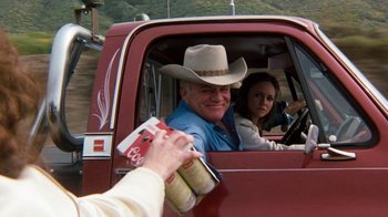 Movie still from “Hooper” (1978), directed by Hal Needham – A man in a cowboy hat in the drivers seat of a red truck; Medium shot, Over the shoulder angle
