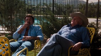 Movie still from “Hooper” (1978), directed by Hal Needham – Two men sitting in lawn chairs next to each other; Wide shot, High angle