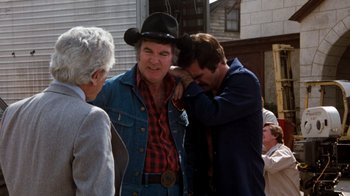 A man wearing a cowboy hat and a blue jacket