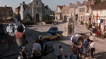 Movie still from “Hooper” (1978), directed by Hal Needham – A group of people standing around a street with cars parked on it; Extreme Wide shot, High angle