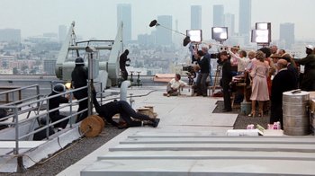 Movie still from “Hooper” (1978), directed by Hal Needham – A group of people sitting on top of a building; Wide shot, High angle