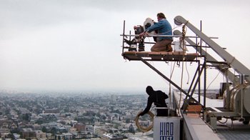 Movie still from “Hooper” (1978), directed by Hal Needham – A man standing on top of a building next to two people; Extreme Wide shot, High angle