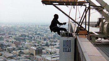 Movie still from “Hooper” (1978), directed by Hal Needham – A man is on a crane working on the side of a building; Extreme Wide shot, Low angle