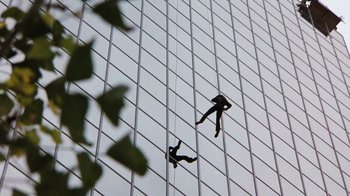 Movie still from “Hooper” (1978), directed by Hal Needham – Two people hanging from a rope on a building; Extreme Wide shot, Overhead angle
