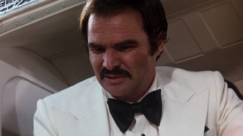 Movie still from “Hooper” (1978), directed by Hal Needham – A person wearing a suit and a bow tie; Close Up shot, Low angle