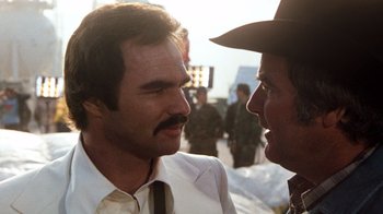 Movie still from “Hooper” (1978), directed by Hal Needham – A man in a suit and a hat talking to another man in a hat; Close Up shot, Over the shoulder angle