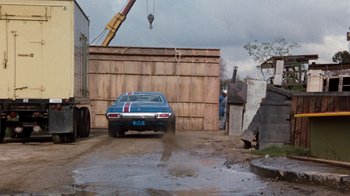 Movie still from “Hooper” (1978), directed by Hal Needham – An old car parked in the middle of the street; Wide shot, Low angle