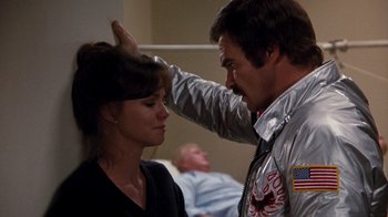 Movie still from “Hooper” (1978), directed by Hal Needham – A woman is getting her hair combed by a man; Close Up shot, Over the shoulder angle
