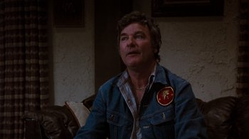 A man wearing a jean jacket and a patch