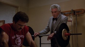 Movie still from “Hooper” (1978), directed by Hal Needham – An older man and a younger man in a room; Medium shot, Over the shoulder angle