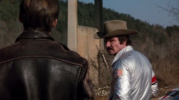 Movie still from “Hooper” (1978), directed by Hal Needham – A man in a cowboy hat talking to another man in a leather jacket; Medium shot, Over the shoulder angle