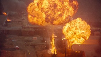 Movie still from “Hooper” (1978), directed by Hal Needham – An explosion is seen in the sky above a street; Extreme Wide shot, Low angle