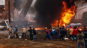 Movie still from “Hooper” (1978), directed by Hal Needham – A group of people standing in front of a fire; Extreme Wide shot, High angle