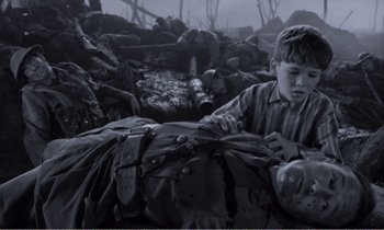 Movie still from “Hope and Glory” (1987), directed by John Boorman – A young boy is holding on to the back of an injured soldier; Medium shot, High angle