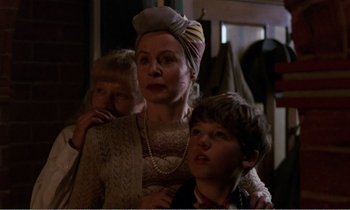 Movie still from “Hope and Glory” (1987), directed by John Boorman – An older woman and two young boys are posing for a picture; Close Up shot, Low angle