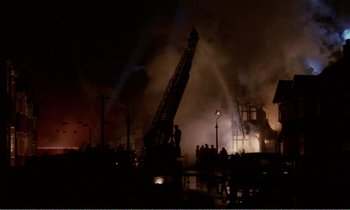 Movie still from “Hope and Glory” (1987), directed by John Boorman – A fire truck is in the middle of the night; Extreme Wide shot, High angle