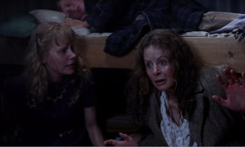 Movie still from “Hope and Glory” (1987), directed by John Boorman – Two women sitting next to each other on a bed; Medium shot, High angle