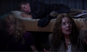 Movie still from “Hope and Glory” (1987), directed by John Boorman – A woman and two children in a dark room; Medium shot, High angle