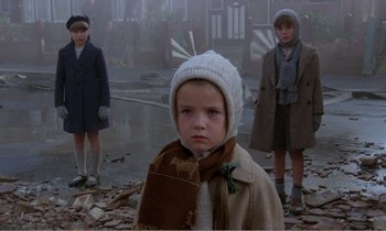 Movie still from “Hope and Glory” (1987), directed by John Boorman – A group of children standing in the middle of a street; Medium shot, Low angle