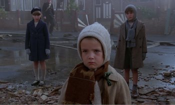 Movie still from “Hope and Glory” (1987), directed by John Boorman – A group of children standing in the middle of a street; Medium shot, Low angle
