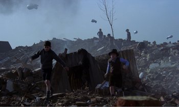 Movie still from “Hope and Glory” (1987), directed by John Boorman – Two children are playing in the rubble of a demolished building; Wide shot, Low angle