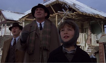 Movie still from “Hope and Glory” (1987), directed by John Boorman – A man and a boy standing next to each other outside; Medium shot, Low angle