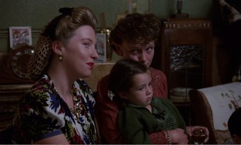 Movie still from “Hope and Glory” (1987), directed by John Boorman – A woman and two children sitting in a living room; Medium shot, High angle