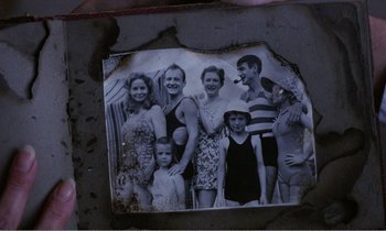 Movie still from “Hope and Glory” (1987), directed by John Boorman – An old photo of a group of people in bathing suits; Extreme Close Up shot, High angle
