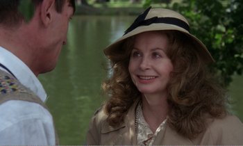 Movie still from “Hope and Glory” (1987), directed by John Boorman – A woman wearing a hat standing next to a man; Close Up shot, Over the shoulder angle