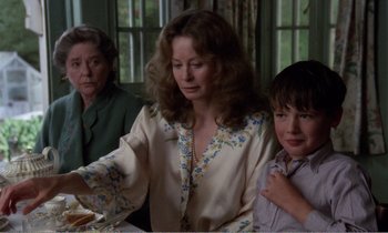 Movie still from “Hope and Glory” (1987), directed by John Boorman – Two women and a boy sitting at a dinner table; Medium shot, Over the shoulder angle