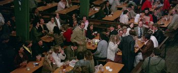 Movie still from “Hopscotch” (1980), directed by Ronald Neame – A group of people sitting at tables eating and drinking; Wide shot, High angle