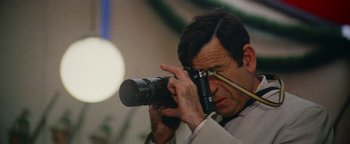 Movie still from “Hopscotch” (1980), directed by Ronald Neame – A man taking a picture with a camera; Extreme Close Up shot, Low angle