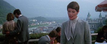 Movie still from “Hopscotch” (1980), directed by Ronald Neame – A woman standing on top of a hill next to two other people; Medium shot, Low angle