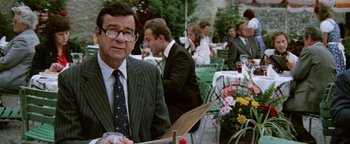 Movie still from “Hopscotch” (1980), directed by Ronald Neame – A man in a suit and tie holding a knife; Medium shot, Over the shoulder angle