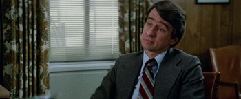 Movie still from “Hopscotch” (1980), directed by Ronald Neame – A person wearing a suit and tie; Close Up shot, High angle