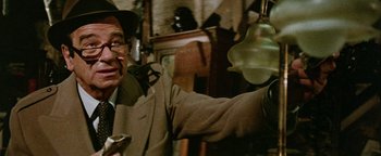 Movie still from “Hopscotch” (1980), directed by Ronald Neame – An old man holding a light in a room; Close Up shot, Over the shoulder angle