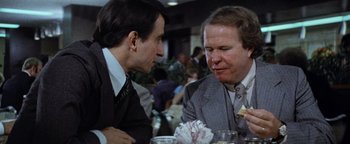 Movie still from “Hopscotch” (1980), directed by Ronald Neame – Two men in business suits sitting at a dinner table; Close Up shot, Over the shoulder angle