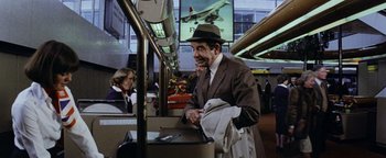 Movie still from “Hopscotch” (1980), directed by Ronald Neame – An older man wearing a suit and a hat is on a train; Medium shot, Low angle