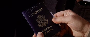 Movie still from “Hopscotch” (1980), directed by Ronald Neame – A person is holding a us passport and a cigarette in their hand; Extreme Close Up shot, Overhead angle