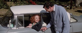 Movie still from “Hopscotch” (1980), directed by Ronald Neame – An older woman sitting in the passenger seat of a car; Medium shot, Over the shoulder angle