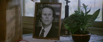 Movie still from “Hopscotch” (1980), directed by Ronald Neame – An old photo of a man in a suit and tie; Close Up shot, High angle