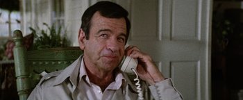 Movie still from “Hopscotch” (1980), directed by Ronald Neame – An older man talking on a phone while sitting down; Close Up shot, Low angle
