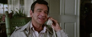Movie still from “Hopscotch” (1980), directed by Ronald Neame – A man talking on a phone while sitting down; Close Up shot, Low angle